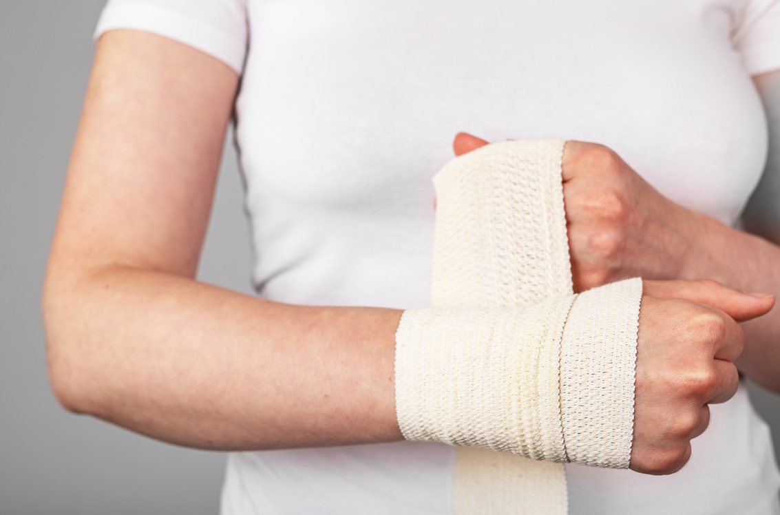 Applying elastic bandage on wounded injured fractured wrist